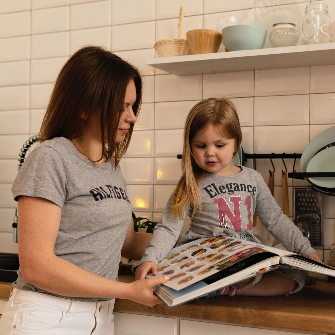 mom reading to her daughter in the kitchen