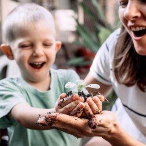 child smiling with plant