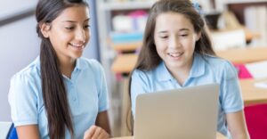 2 girls looking at laptop
