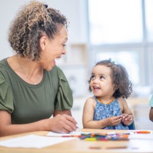 teacher working with young girl in preschool