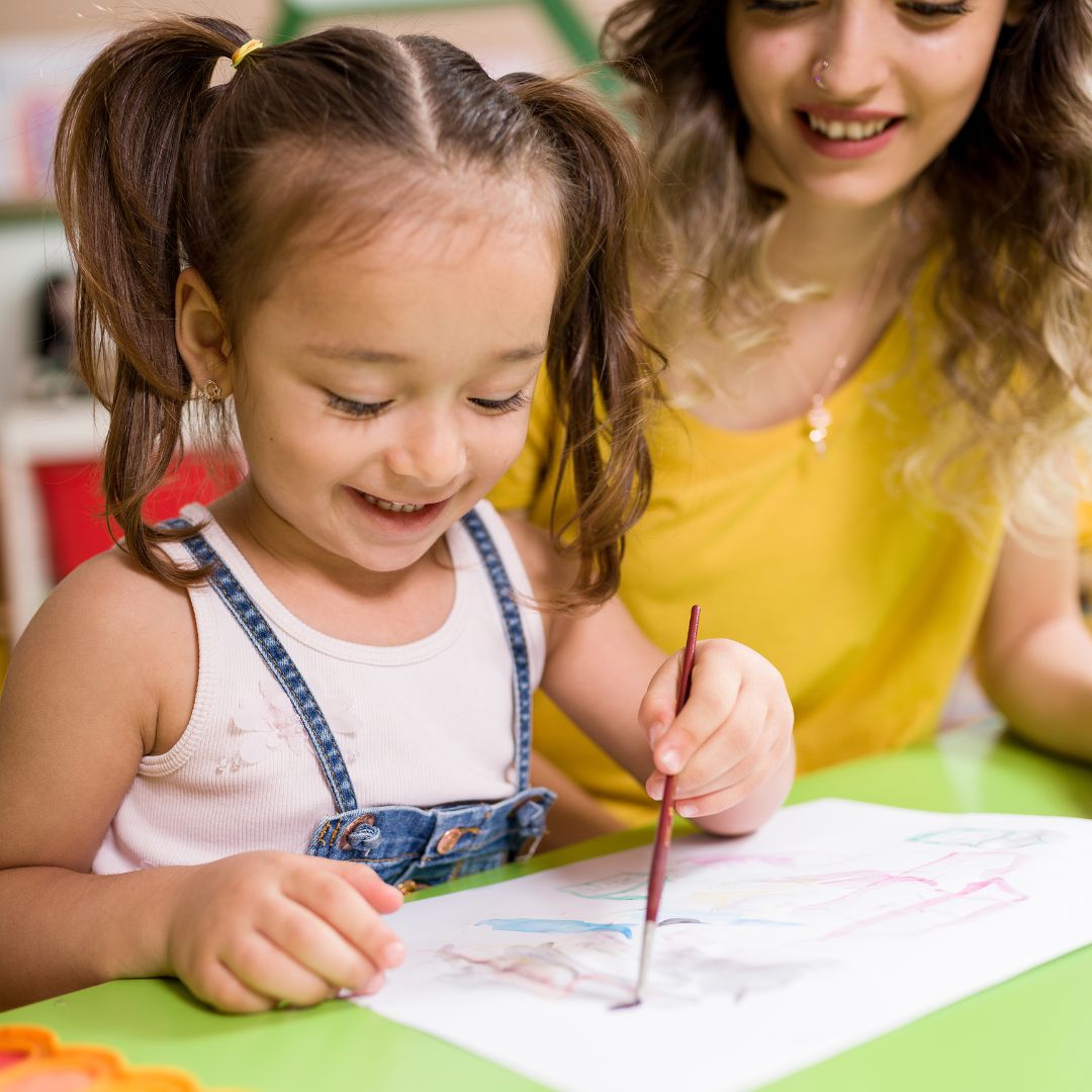 Preschooler learning with teacher.