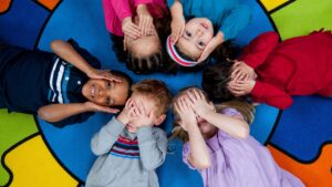 kids lying on the ground with their heads together