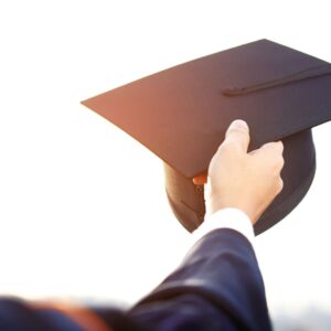 A student holding up his graduation cap
