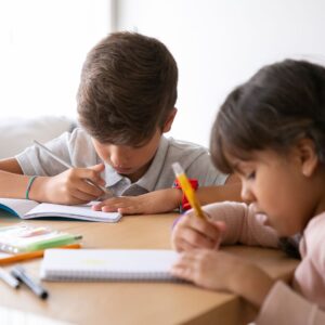 two kids studying at a table