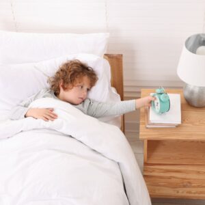 boy setting alarm clock
