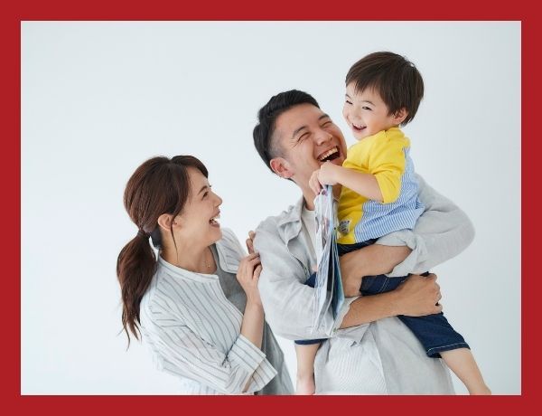 parents holding a smiling preschool boy